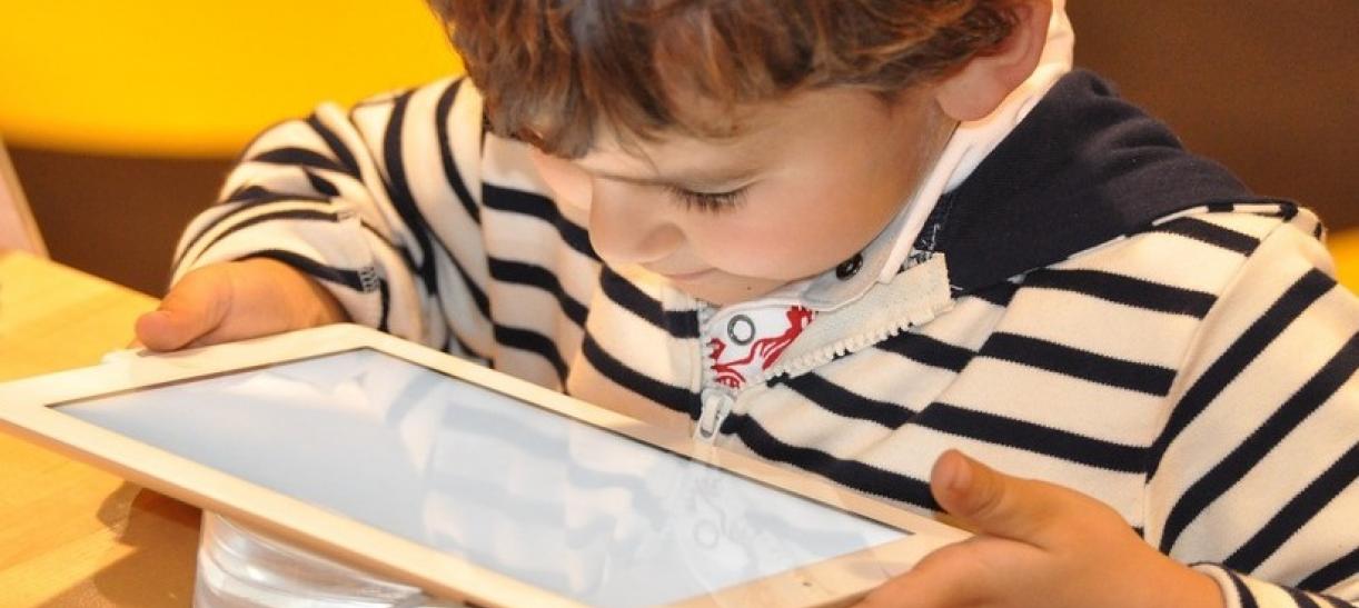 Imagen de un niño mirando fijamente una tablet