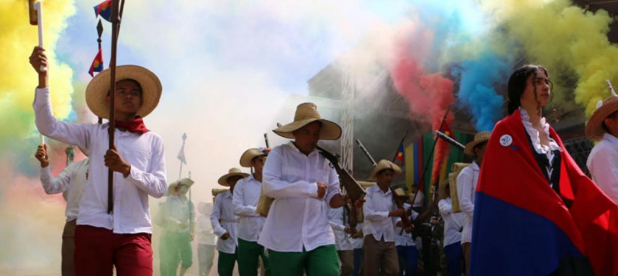 Imagen de varias personas festejando con bengalas de color amarillo, azul y rojo