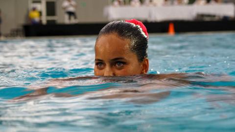 Una joven nadadora compite en una piscina de los Juegos Nacionales.