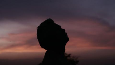 Un hombre mayor con el atardecer de fondo.
