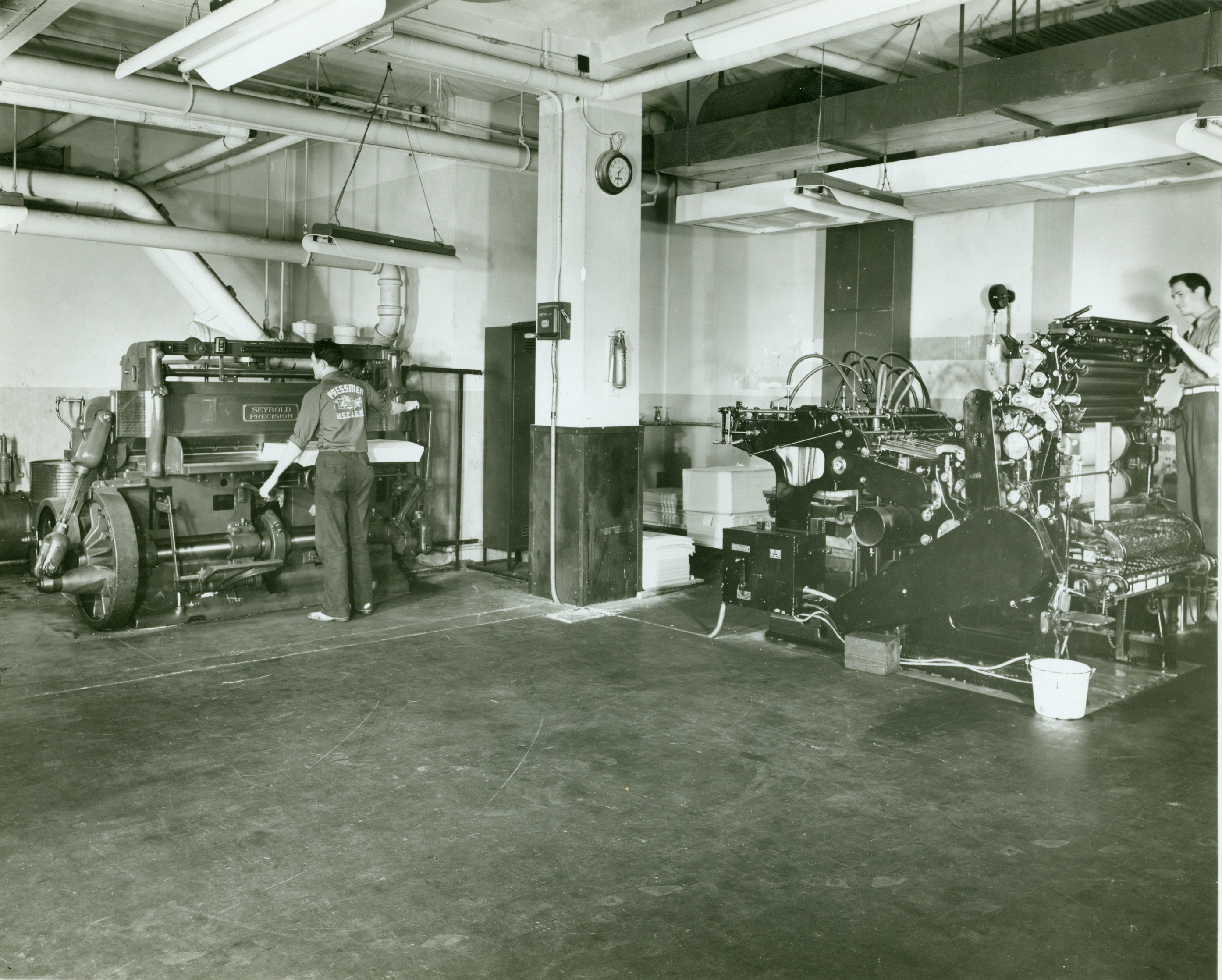 A Harris press to the right and the Seybold-Harris guillotine paper cutter tothe left