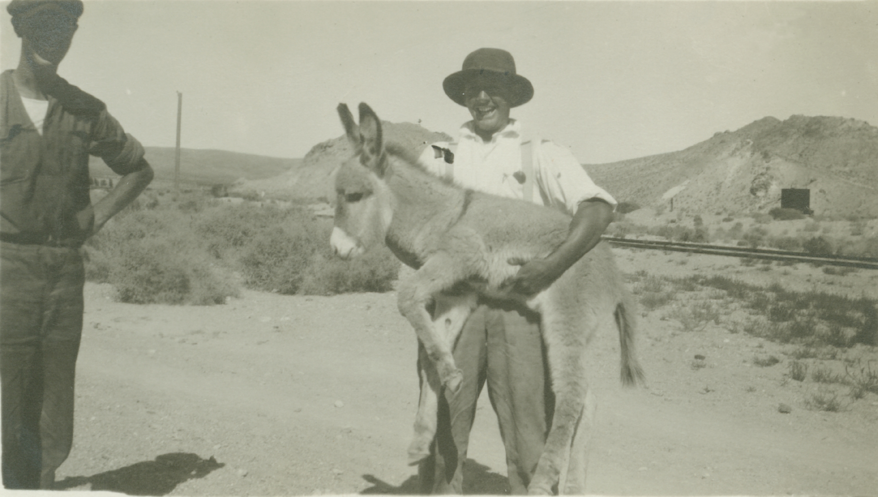 Member of level crew posing with a good-natured burro