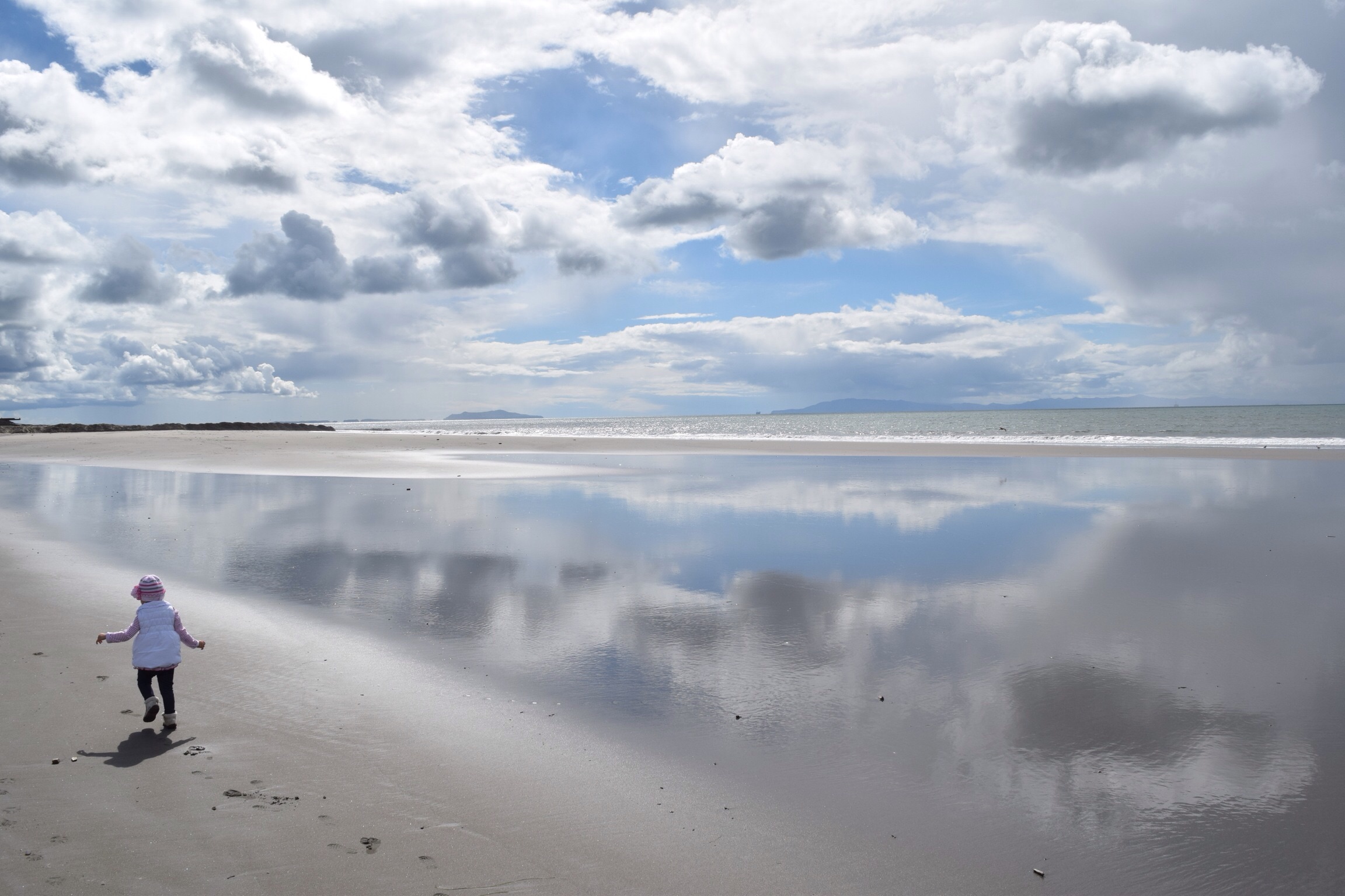 Clouds reflecting in a shallow pool left at low tide