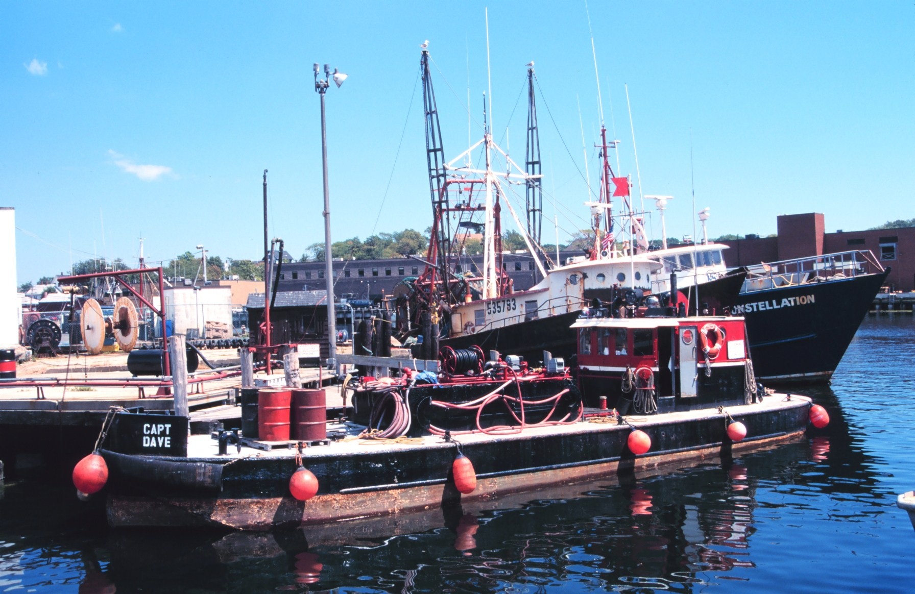 Trawlers tied up behind a small barge