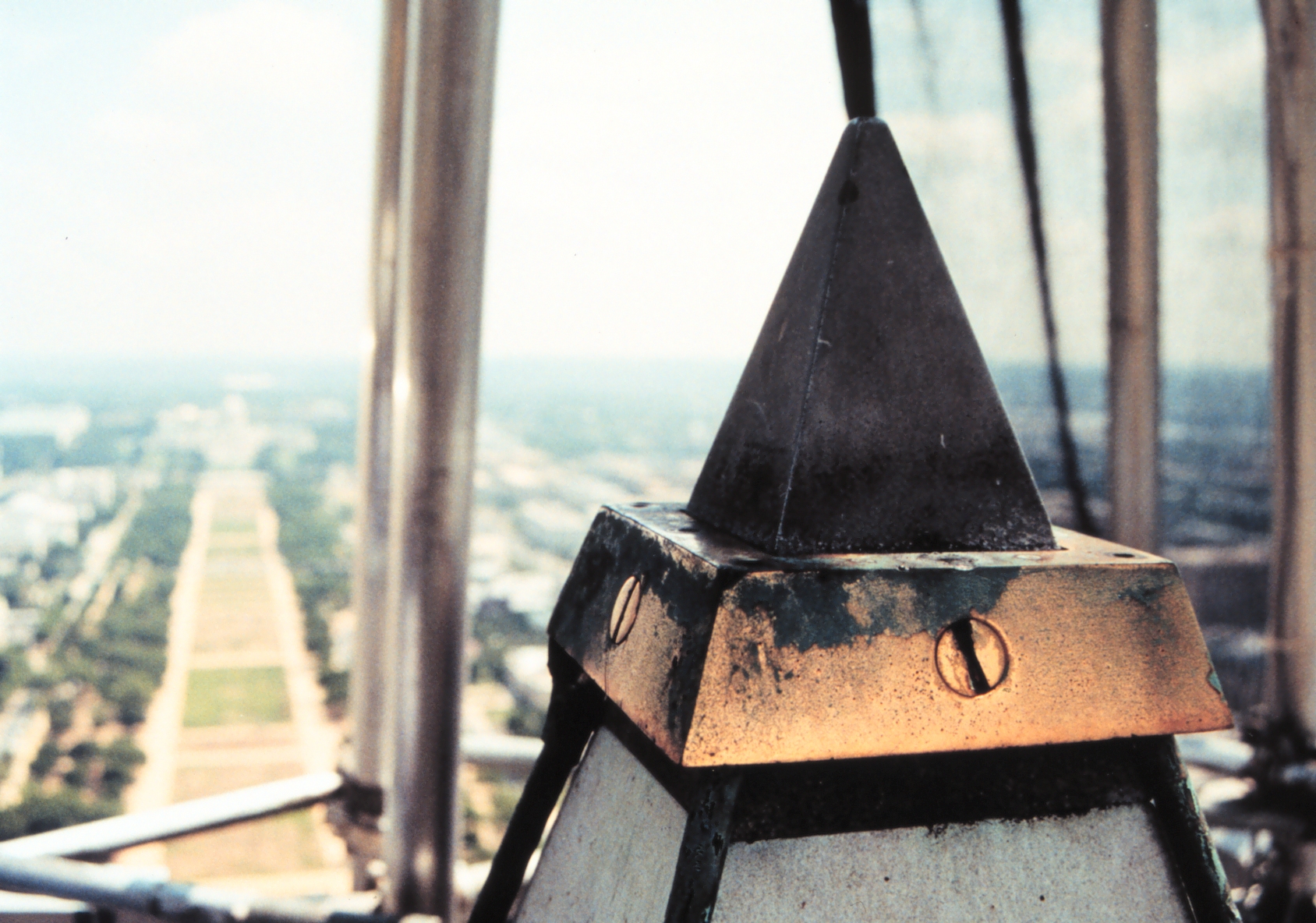 Aluminum tip of the Washington Monument with brass collar that holdslightning rods and brass rods extending down each side of the monument