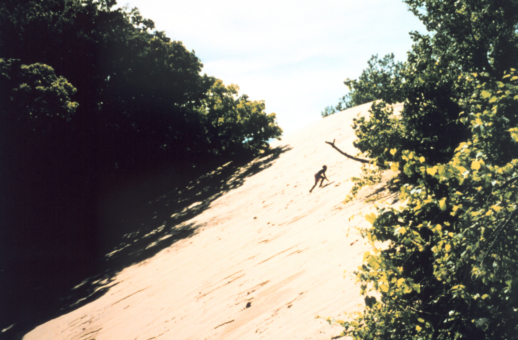Boy climbing a large dune