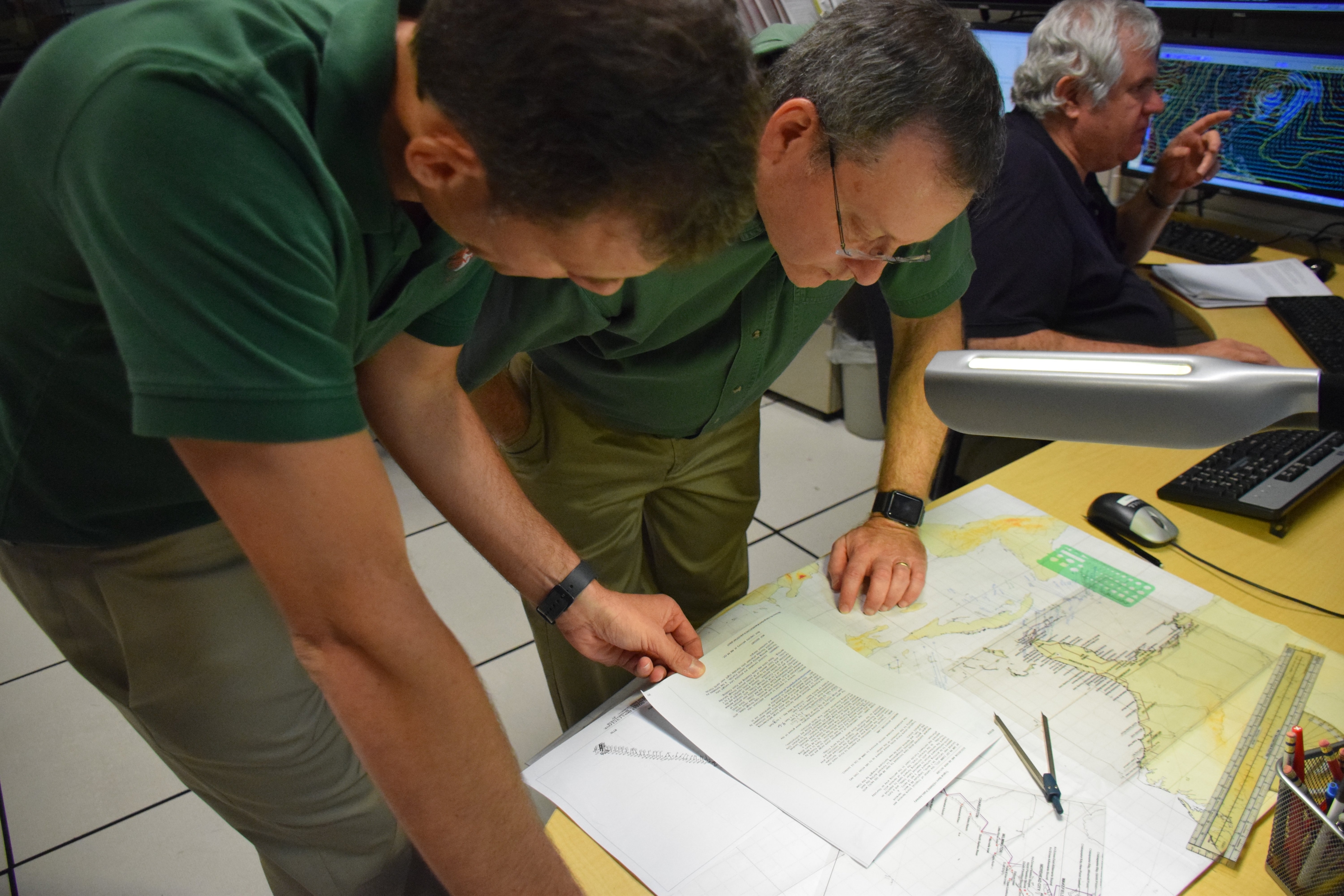 National Hurricane Center meteorologist at work studying a hurricane