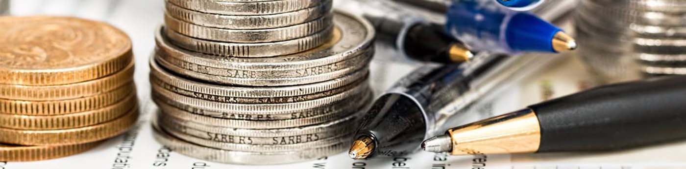 The banner has a close up picture of a small pile of copper and silver coins along with a few pens placed on a sheet of paper.
