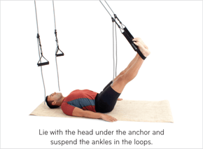Lie with the head under the anchor and suspend the ankles in the loops.