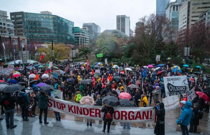 Image shows hundreds of people gathered outside the Vancouver Art Gallery holding signs and banners opposing Kinder Morgan.