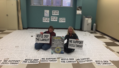 Here is a picture of our members, Wendy and Karen, with the signatures of over 100,000 of SumOfUs members from around the world right before they were delivered on the first day of the trial!
