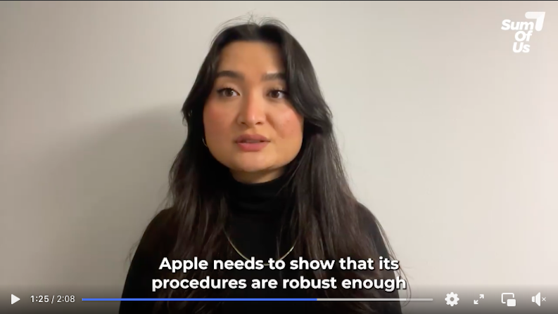 video still of Uyghur woman with long dark hair wearing a black high neck jumper and gold necklace against a light background facing the camera She is speaking and subtitles read Apple needs to show that its procedures are robust enough