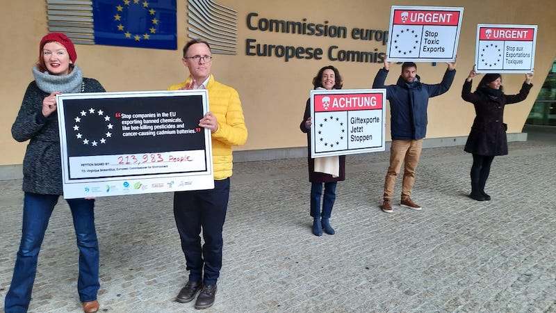 Photo of campaigners just outside European Commission HQ building in Brussels holding placards, photographed 1 December 2022