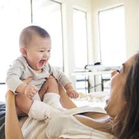 Begins to smile at people