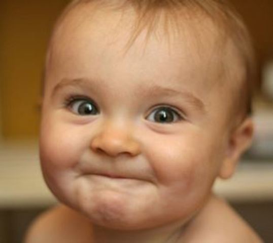 Begins to smile at people