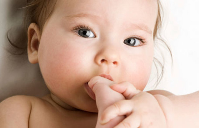Baby brings hand to mouth