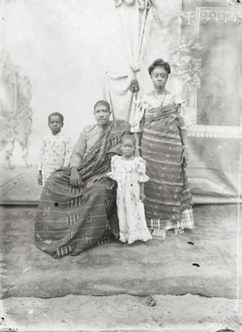 ​Family with two children, parents in Ewe kente cloth with painted backdrop
