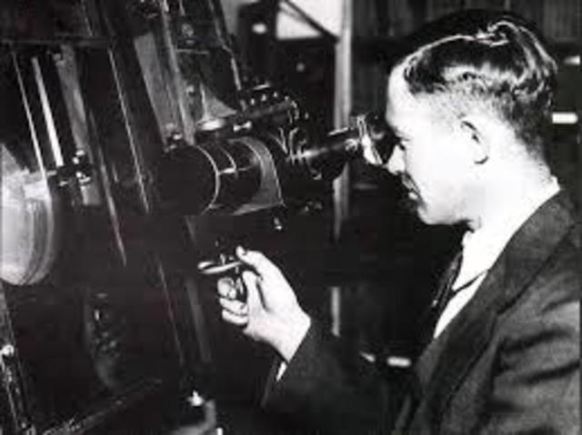 Clyde Tombaugh discovers Pluto. Tombaugh discovered Pluto by comparing photographic plates taken of the same region of the sky about a week apart. Pluto's image moved among the stars.