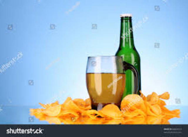 (8)Auf einem Tisch standed Bierflaschen und Schusseln mit chips und Saltstangen