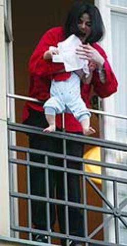 Jackson muestra por el balcón de un hotel de Berlin a su primer hijo, Prince Michael II, cuando éste es tan sólo un bebé, a los miles de admiradores que observan desde la calle.