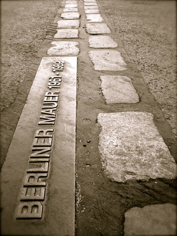 Πέτρινες πλάκες κατά μήκος της διαδρομής του Τείχους και μεταλλικές επιγραφές αναγράφουν:   “Berliner Mauer 1961-1989”.