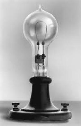 Thomas Edison uses a light bulb to light a lamp.
