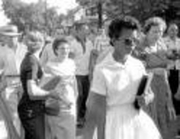 Eisenhower sends troops to enforce school desegregation.