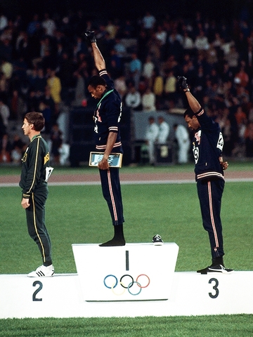Deux athlètes americains lèvent le poing contre les inégaliés raciales.