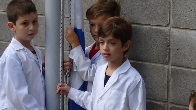 Cantando e izando la bandera.