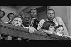 Reverend Sykes helps the kids find a seat in the crowded courthouse.
