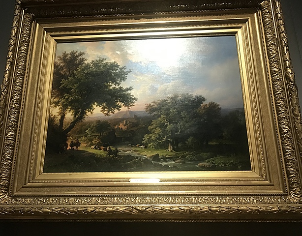 Boomachtig landschap met een rustende herder bij een zonnig pad en schapen