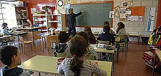 Disposició de taules per parelles i inici d'ordinadors a l'aula