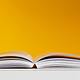 White book in white table near yellow wall 3760323