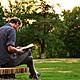 Man reading book outside
