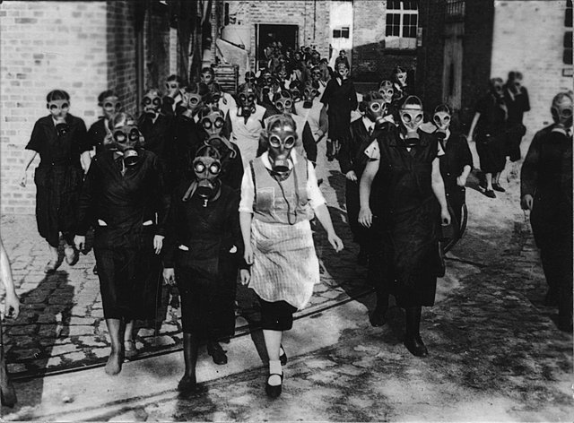 Los trabajadores de fábrica practican el uso de máscaras de gas.