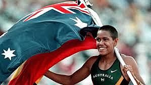 Cathy Freeman carries Australian and Aboriginal flags on victory lap