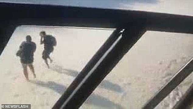 Brazilian police fly a helicopter to create a sandstorm and chase people off a beach to enforce coronavirus lockdown - as GANGS vow to enforce curfew in Rio's favelas