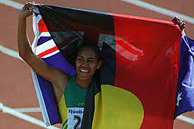 Cathy Freeman carries the Indigenous flag at the Commonwealth Games