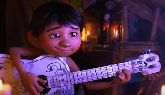 Miguel plays guitar behind his family’s back.