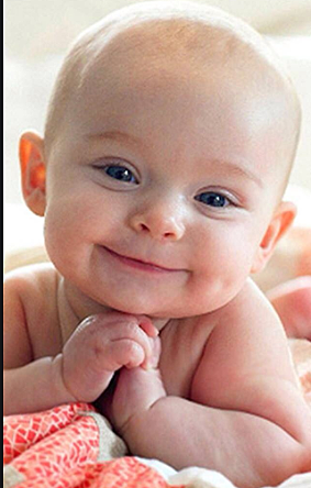 Begins to smile at people