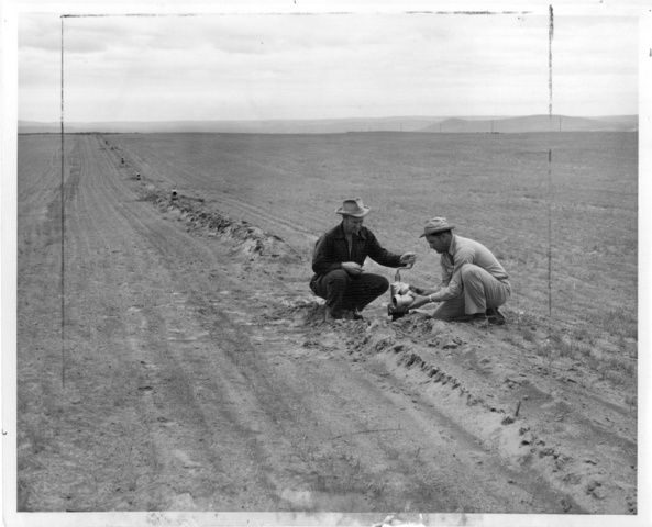 A.L. Hales and son check an aluminum valve for the sprikler irrigation system on the Hales farm