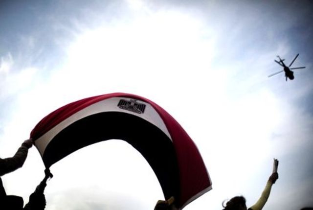 Fighter planes and helicopters fly over Tahrir Square.