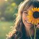 Mujer con girasol tapandole el rostro