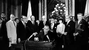 President Johnson signs voting act.