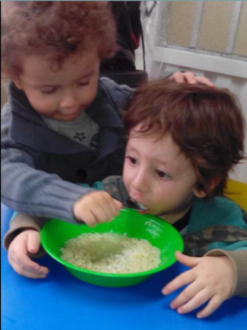 En la guardería de las monjitas ayudando a comer a mis amigos