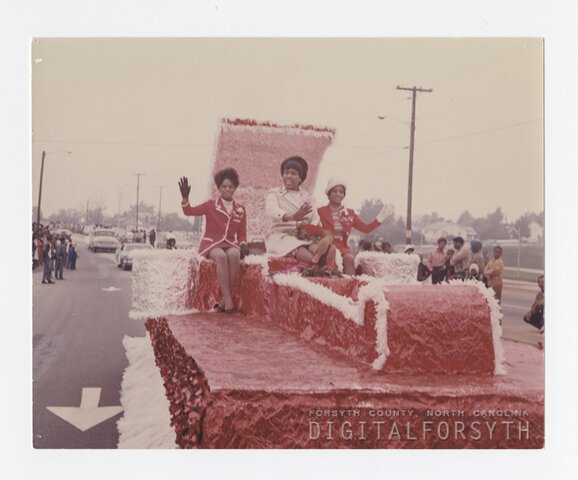 Miss Alumni and court riding in the homecoming parade