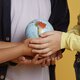 Happy school friends holding an earth globe