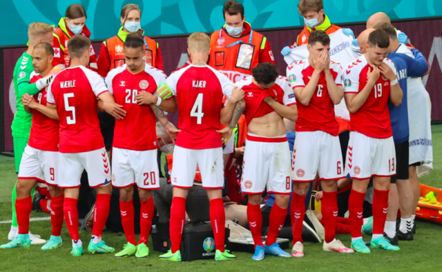 Danish soccer players circle their teammate Christian Eriksen as paramedics work on him, he needed to be resuscitated with CPR and a defibrillator.