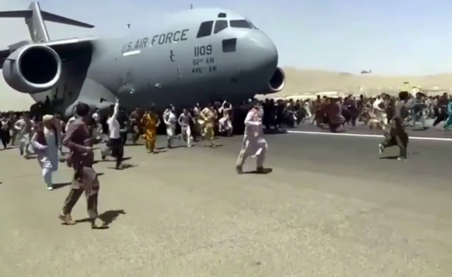 Afghans run along side the US Air Force transport, after the Taliban takeover, many desperate to leave the country.