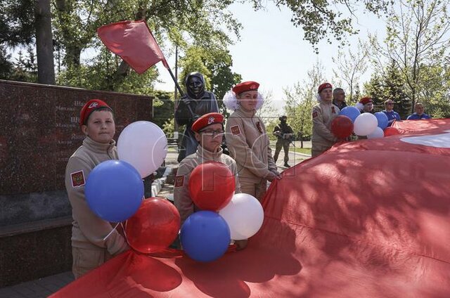 La popolazione locale partecipa a una cerimonia della Fiamma Eterna durante le celebrazioni del Giorno della Vittoria